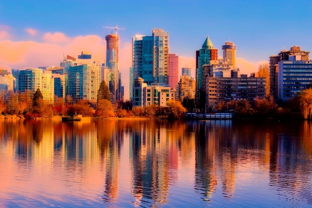 qué visitar en Canadá Skyline de la ciudad de Vancouver en Canadá con la puesta de sol y los edificios que se reflejan en el mar